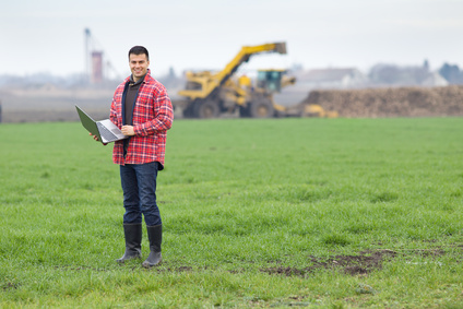 Peasant with laptop in field